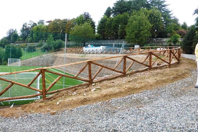 Barriera in legno tipo Mongreno e terra rinforzata sullo sfondo appena realizzata presso campo da football a Torino.